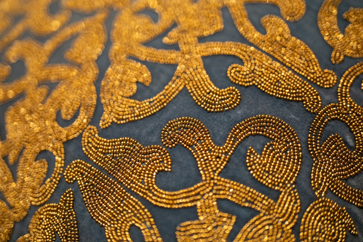 Close-up of gold zardozi beadwork on an indigo ground